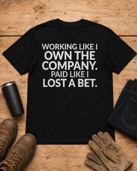 Working Like I Own the Company Work Humor Shirt in Black workbench flat lay