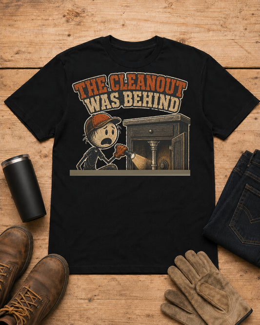 The Cleanout Was Behind the Cabinet Plumber T-Shirt in Black workbench flat lay