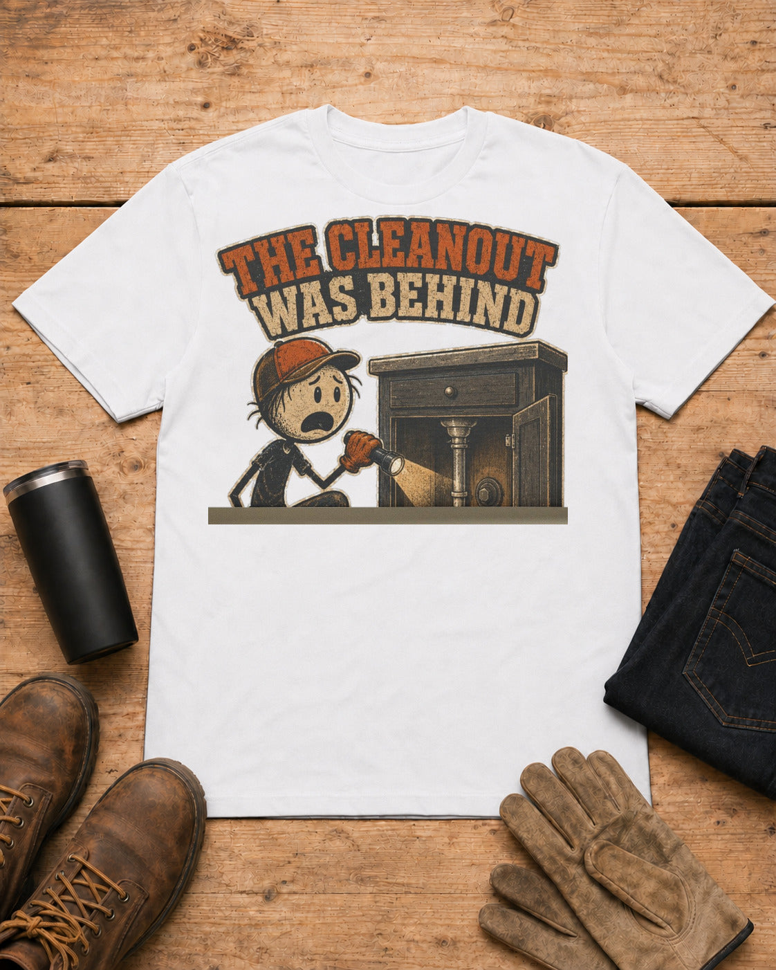 The Cleanout Was Behind the Cabinet Plumber T-Shirt in White workbench flat lay