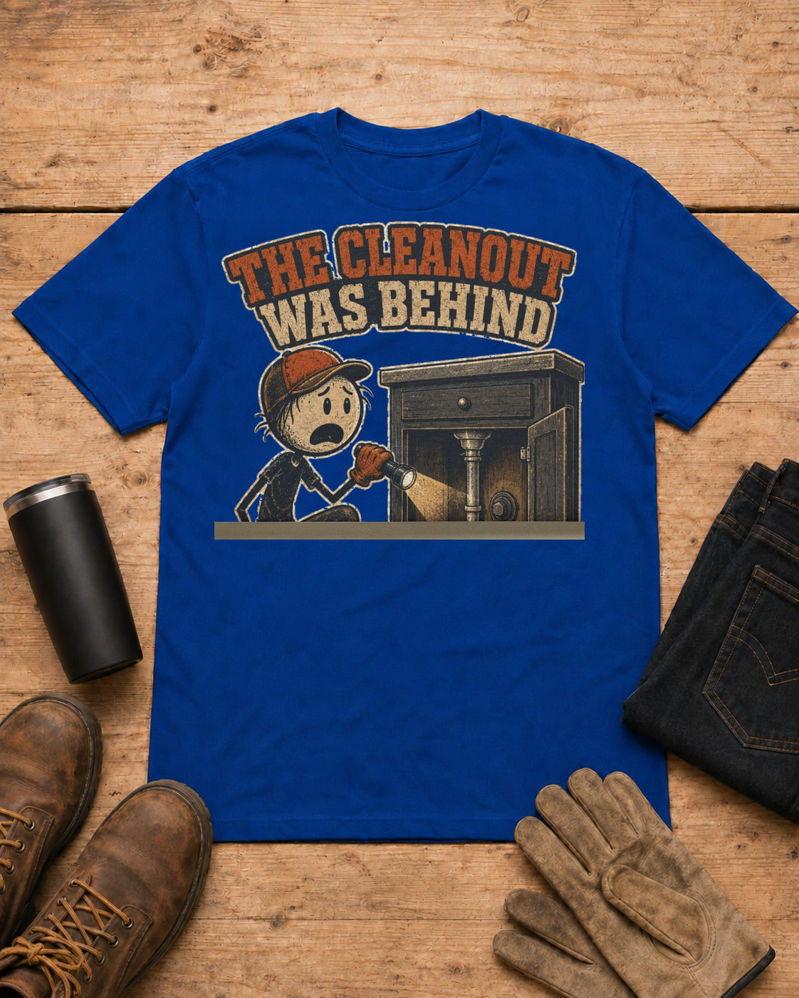 The Cleanout Was Behind the Cabinet Plumber T-Shirt in Royal Blue workbench flat lay