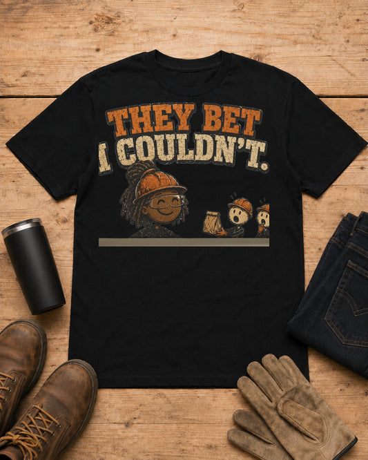 They Bet I Couldn't Funny Tradeswoman T-Shirt in Black workbench flat lay